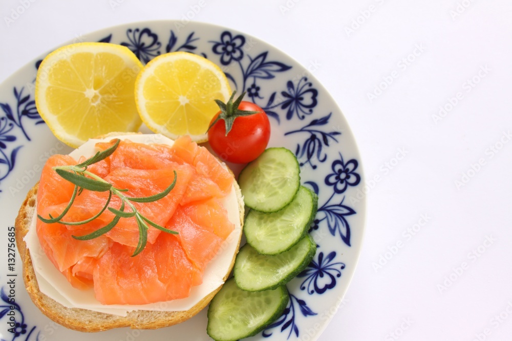 belegtes brötchen mit lachs und käse, gurke, tomate und zitrone