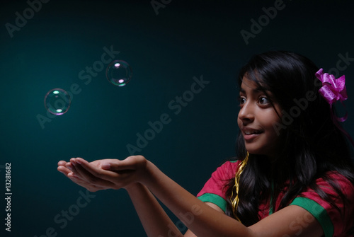 Girl try to catch soap bubbles