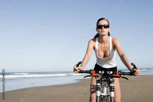 Junge Frau am Strand fährt Fahrrad