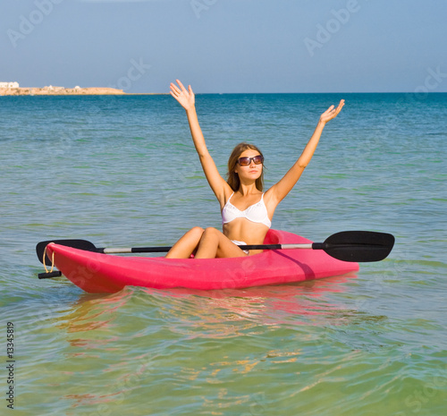Girl in bikini sailing a kayak