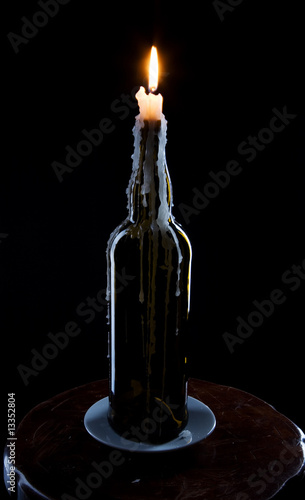 A candle burns in the bottles
