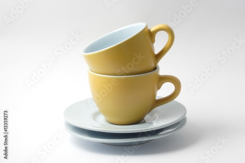 due tazzine gialle per caffè con piattini