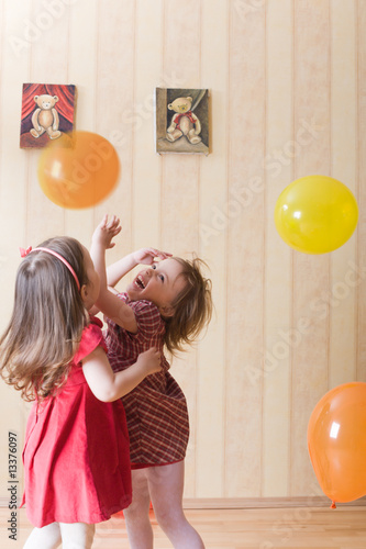 Portrait of two little girls playing with airy balls photo