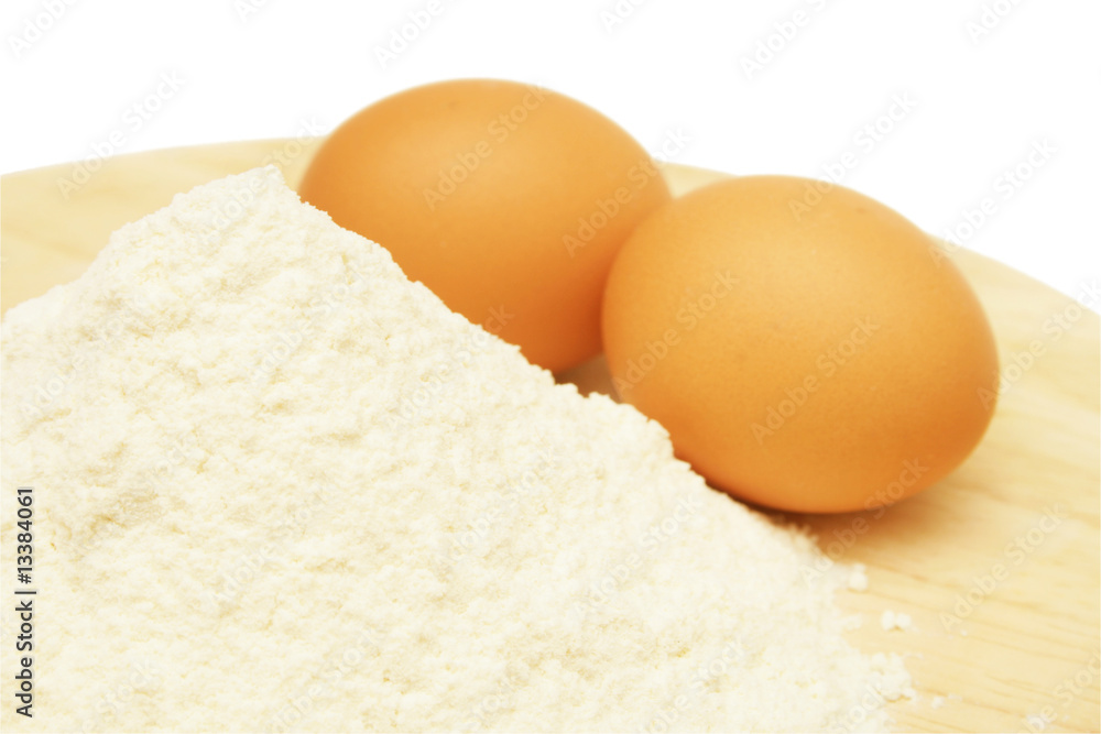 Eggs and flour on wooden plate. Eggs and flour on wooden plate.