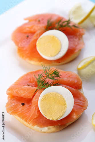Smoked salmon on bagel with fresh black pepper and egg.