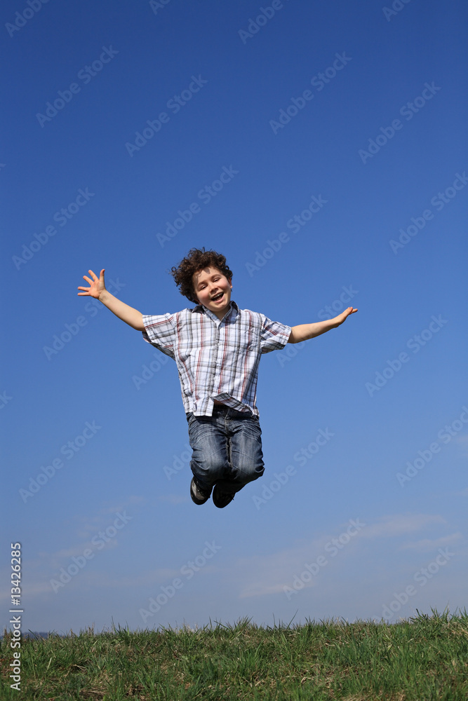 Boy jumping, running against blue sky Boy jumping, running against blue sky