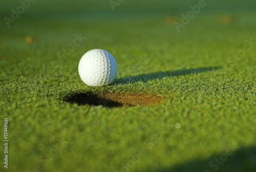 Golf ball on next to hole