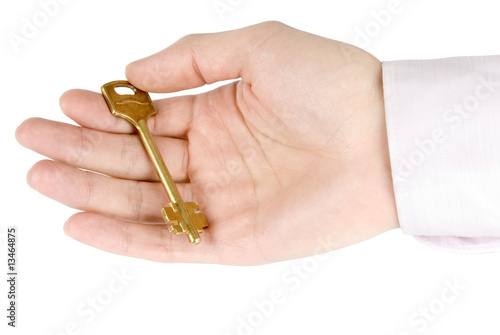Golden key in the hand isolated on white