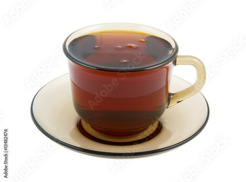 Glass cup of hot tea on plate isolated