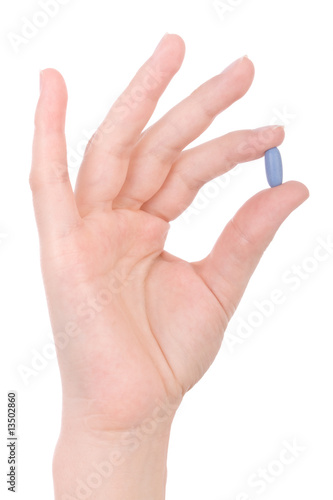 Hand holding a blue pill isolated on white.