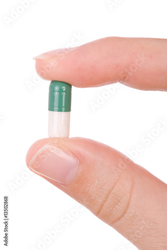 Hand holding a capsule or pill close up