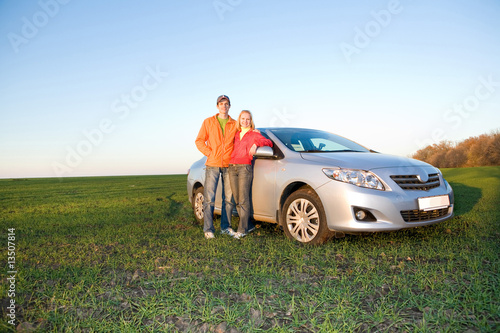 Happy young couple with new car