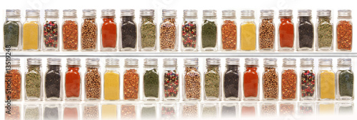 Assorted spices on two layer shelves against white