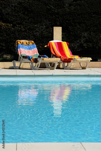 zwei Liegen mit Handtücher bedeckt an einem swimming pool