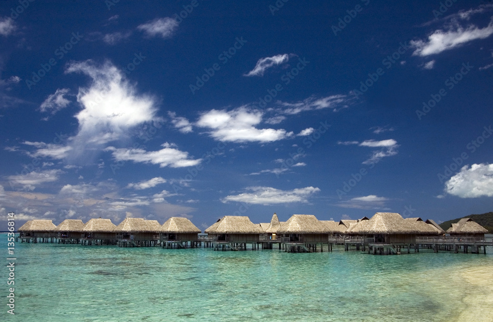 beach bungalows at tropic lagoon under blue sky