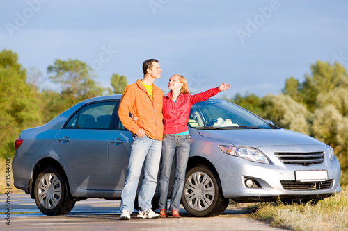 Happy young couple with their new car. Woman show something © Eduard Stelmakh