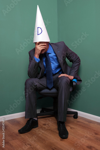 Businessman wearing a dunce hat