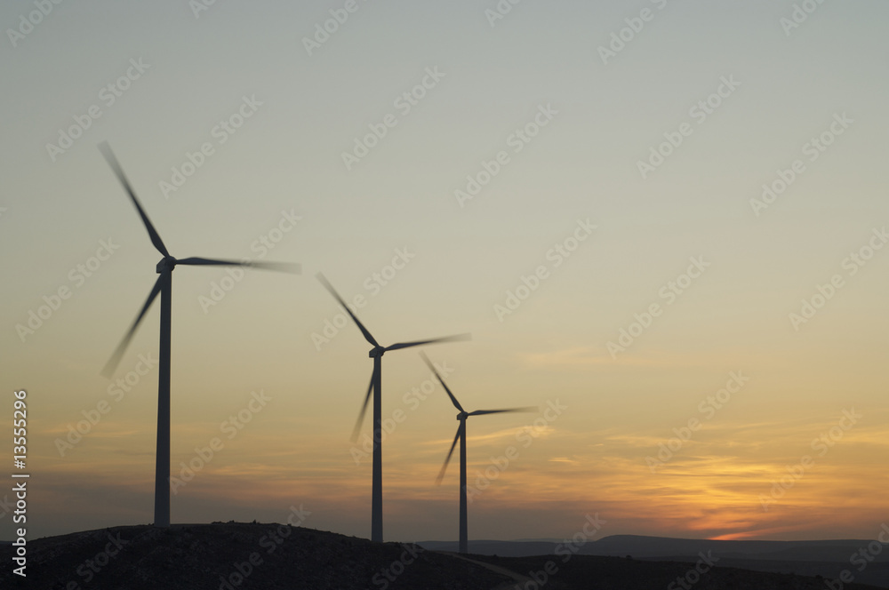 three wind power aerogenerators skyline at dusk