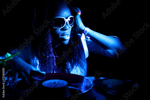 cool afro american DJ in action under blue light