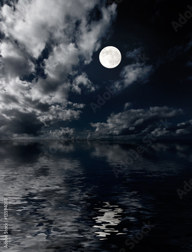 Moon and clouds above sea at night