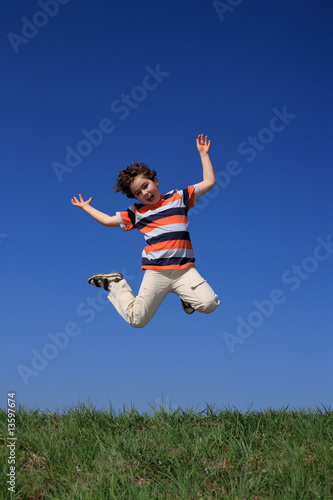 Boy jumping against blue sky