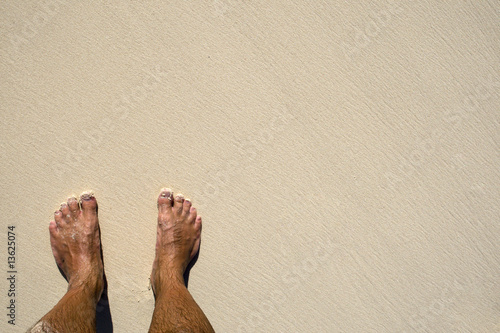 Tanned legs on sand beach