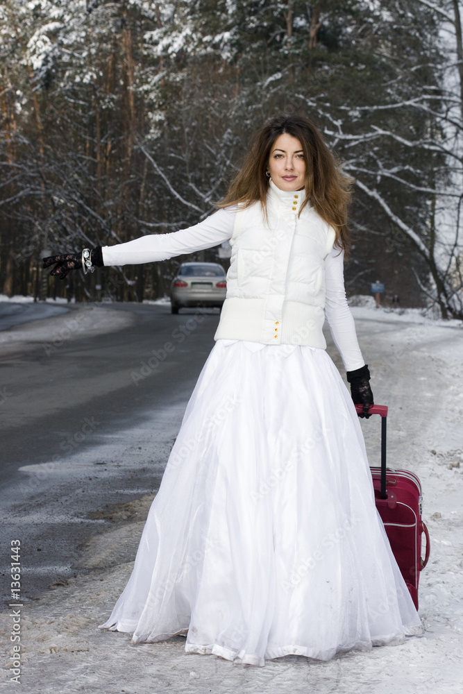 Eloping bride in winter with bag Eloping bride in winter with bag
