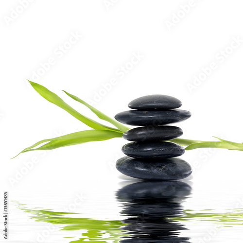 stack black stones with bamboo leaf with reflection