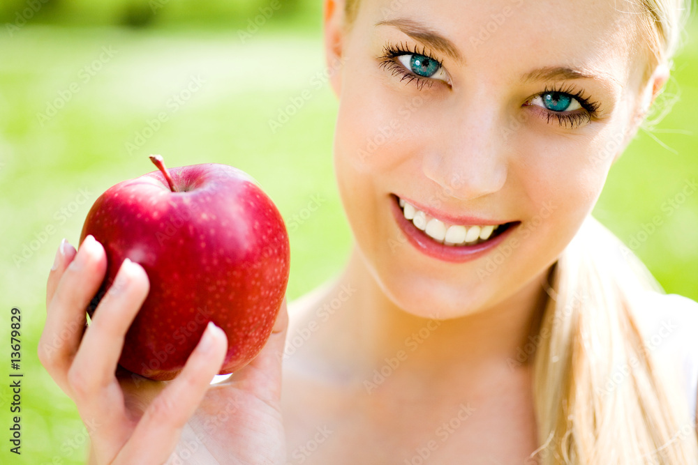 Young woman holding apple, smiling Young woman holding apple, smiling