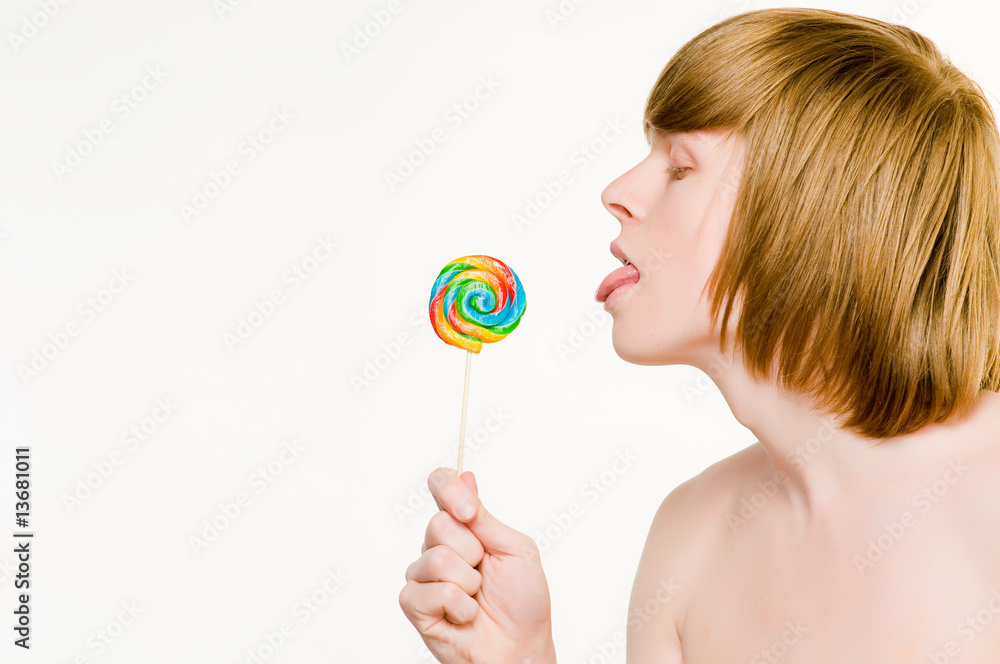 Young red-haired man licking lollipop