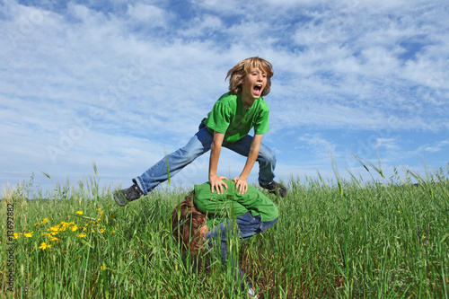 healthy kids playing leapfrog outdoors in summer