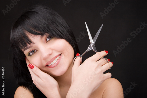 Lovely brunette with scissors of the hairdresser