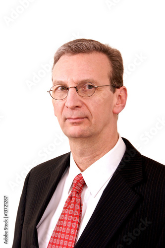 portrait of older stern looking executive man on in suit over wh