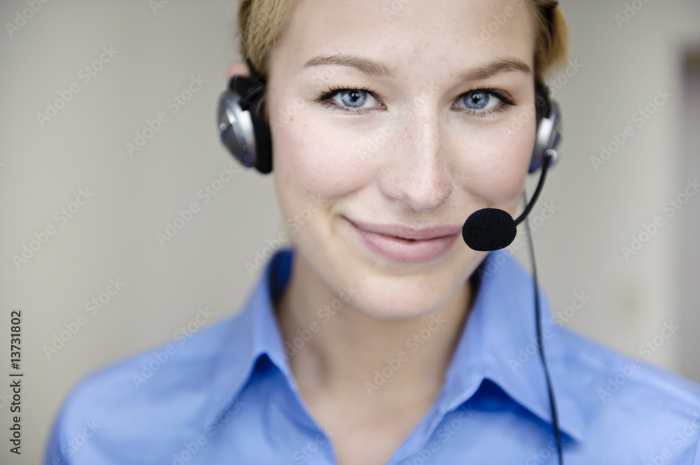 freundliche frau telefoniert mit headset in büro freundliche frau telefoniert mit headset in büro