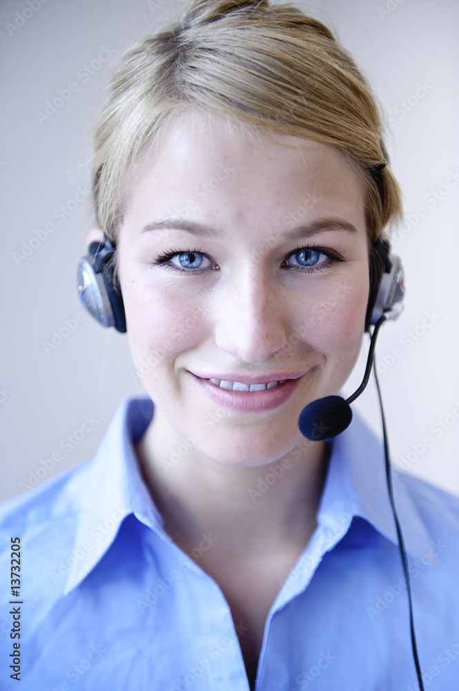 freundliche frau telefoniert mit headset in büro freundliche frau telefoniert mit headset in büro