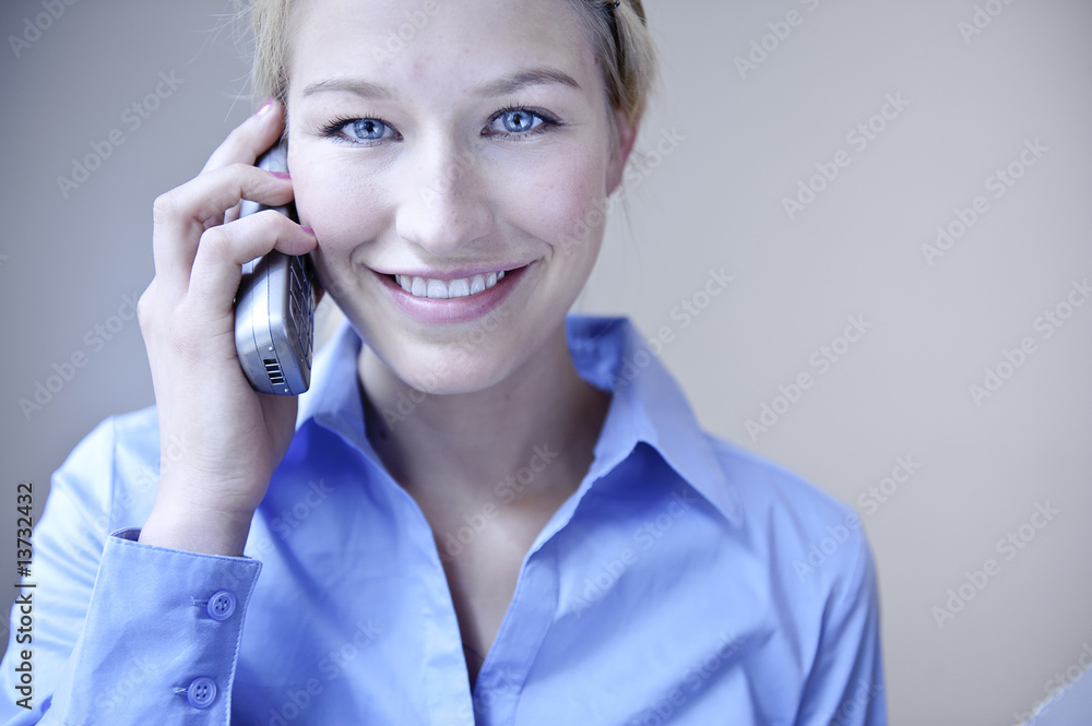 blonde frau schaut freundlich und telefoniert blonde frau schaut freundlich und telefoniert