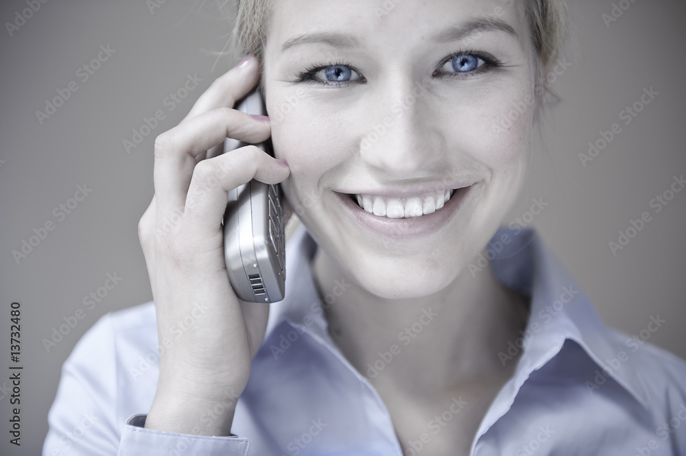 blonde frau schaut freundlich und telefoniert blonde frau schaut freundlich und telefoniert