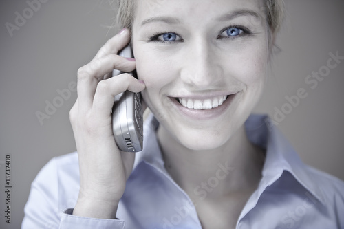 blonde frau schaut freundlich und telefoniert