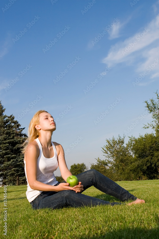 pretty woman eating green apple on the summer glade pretty woman eating green apple on the summer glade