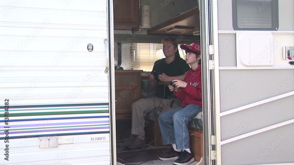 Two people playing video games inside an R.V. Trailer Two people playing video games inside an R.V. Trailer