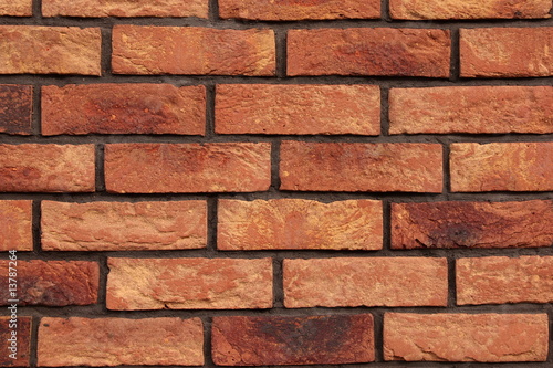 A brick wall made of red and orange brick