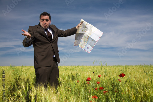 businessman lost in field using a map