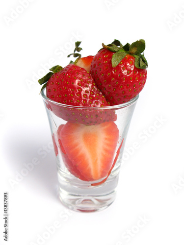 Strawberries cut in a glass on white background