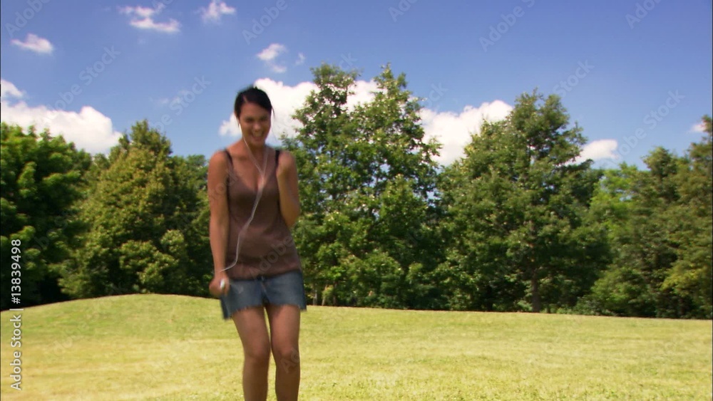 junge frau musik hörend, tanzend und springend auf wiese junge frau musik hörend, tanzend und springend auf wiese