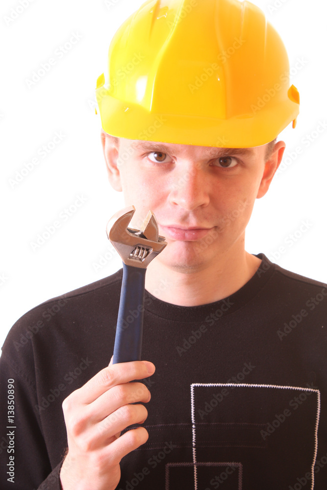 Young man with adjustable wrench in yellow helmet isolated on wh Young man with adjustable wrench in yellow helmet isolated on wh