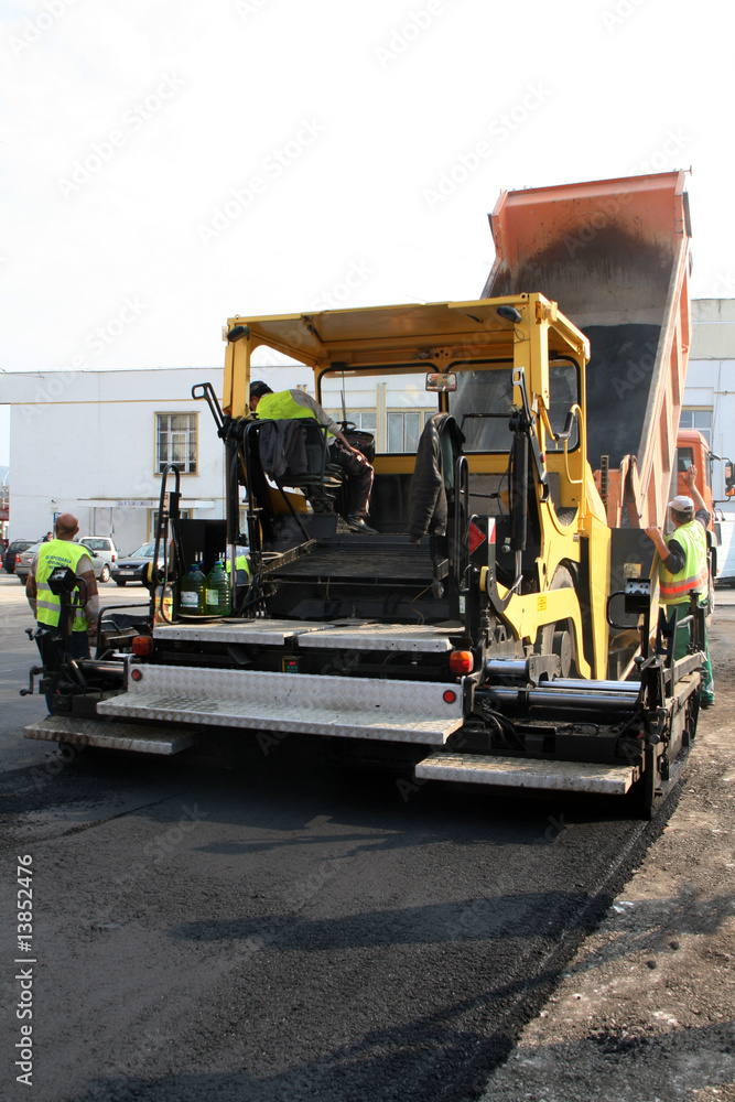 Machinery and workers repairin asphalt road