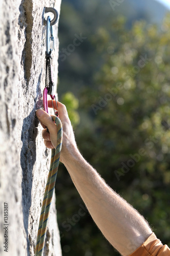 Main d'un alpiniste sécurisé par un mousqueton.