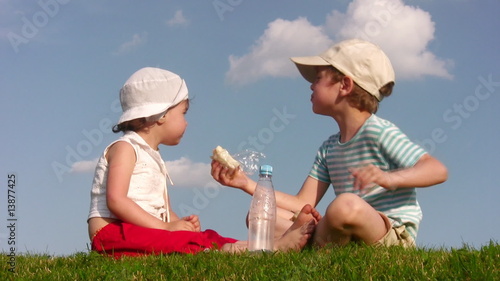 children with food on meadow photo