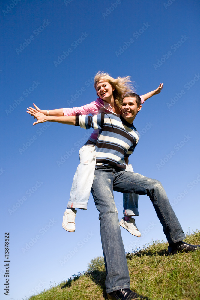 Happy Young love Couple - jumping under blue sky Happy Young love Couple - jumping under blue sky