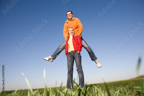 Happy smiling couple jumping in blue sky
